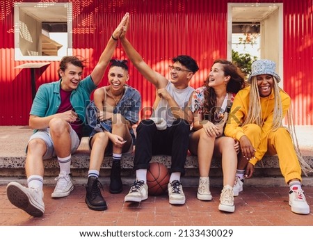 Here's to friendship. Group of multiethnic young people enjoying hanging out together outdoors in the city. Cheerful generation z friends having fun and making happy memories. Stok fotoğraf © 