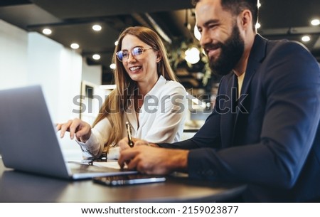 Foto Bild Fröhlicher junger Mann arbeitet am Laptop mit Kopfhörern