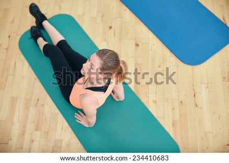 Top view of fitness woman exercising on a fitness mat . Fit woman working out at gym.
