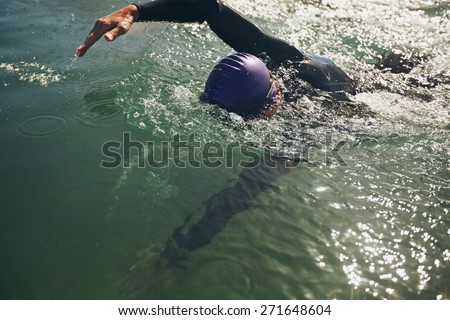 Male swimmer swimming in open water. Athlete practicing for the competition.