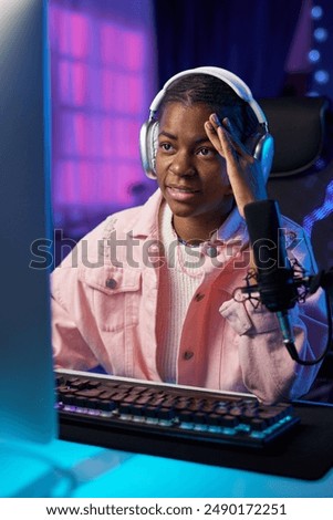 Similar – Image, Stock Photo Teenager girl playing video game at home. Gamer playing online in dark room lit by neon lights. Competition and having fun