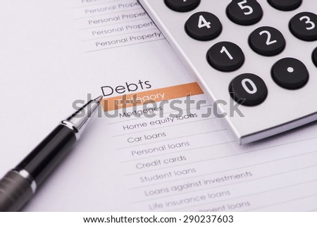 business financial analysis (debt) with pen  & calculator