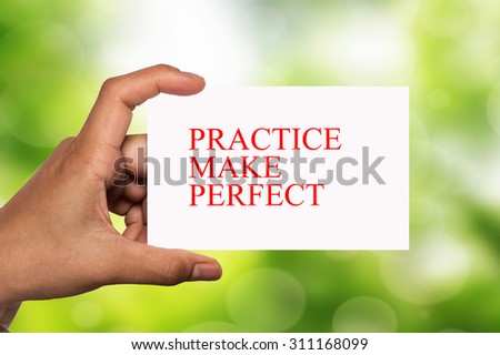 hand holding white card written practice make perfect over blur background