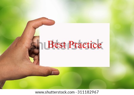 hand holding white card written best practice over blur background
