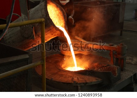 Molten iron pour from ladle into melting furnace ; foundry porcess 商業照片 © 