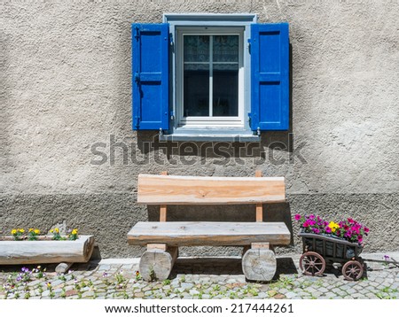 Window with flower  on ledge in a village, eastern of Switzerland. Small truck, stylized as flower pot.