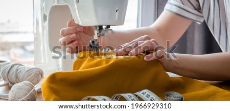 Sewing. Recycling Made by hand from home. sewing machine  project quarantine, lockdown. home sewing,Hobby, meditation,zero waste,recycling. Girl sews clothes home  sewing machine, ecology zero waste Foto stock © 