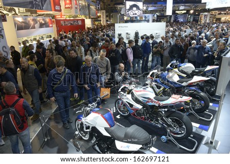MILAN, ITALY - NOVEMBER 8: People visit BMW  motorcycles and scooters exhibition area at EICMA, 71st International Motorcycle Exhibition on November 8, 2013 in Milan, Italy.
