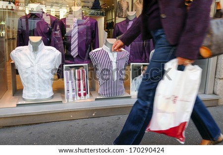 MILAN, ITALY - SEPTEMBER 26: a woman walks by a window fashion shop of Milan, Italy. September, 26 2008.