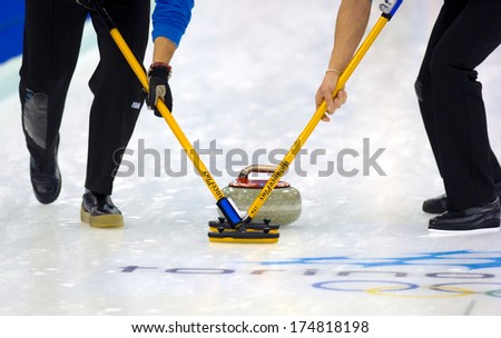TURIN, ITALY-FEBRUARY 19, 2006: Close up of Curling stones sliding on ice during the Winter Olympic Games of Turin 2006.