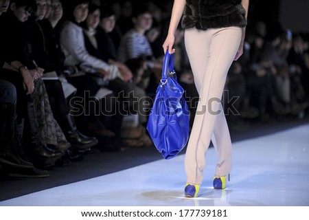 MILAN, ITALY-MARCH 01, 2010: Model with blue bag and audience in the background, on runway catwalk during the spring-summer fashion collection of Mila Schon.
