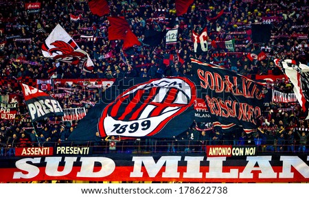 MILAN, ITALY-FEBRUARY 19, 2014: AC Milan fans waving a team flags during a soccer UEFA Champions League match AC Milan vs Athletic Madrid, at  the San Siro stadium.