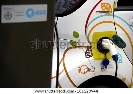 MILAN, ITALY-FEBRUARY, 23, 2012: Electric car recharging the battery on a car sharing dedicated parking spot, in downtown Milan.