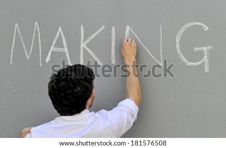 MILAN, ITALY-APRIL 17, 2012: Young designer chalk writing on wall, during the Fuori Salone of the Design Week, at Ventura-Lambrate design area, in Milan.