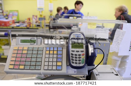 VARESE, ITALY-APRIL 11, 2014: Cash register, and supermarket customers paying their shopping to cashiers, in Varese.