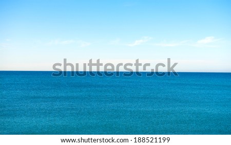 Blue sea horizon line, with blue sky and withe clouds.