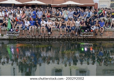 MILAN, ITALY-JUNE 20, 2014: italian soccer fans reflected on the Naviglio Grande canal, watching on a wide screen the Brazil 2014 World Cup football match Italy vs Costa Rica, in Milan.