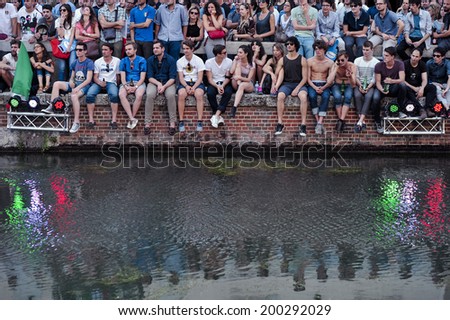 MILAN, ITALY-JUNE 20, 2014: italian soccer fans reflected on the Naviglio Grande canal, watching on a wide screen the Brazil 2014 World Cup football match Italy vs Costa Rica, in Milan.