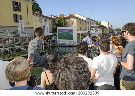 MILAN, ITALY-JUNE 20, 2014: italian soccer fans on the Naviglio Grande canal, watching on a wide screen tv the Brazil 2014 World Cup football match Italy vs Costa Rica, in Milan.