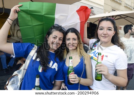 MILAN, ITALY-JUNE 20, 2014: italian soccer fan girls holding the italian flag, watching the Brazil 2014 World Cup football match Italy vs Costa Rica, in Milan.