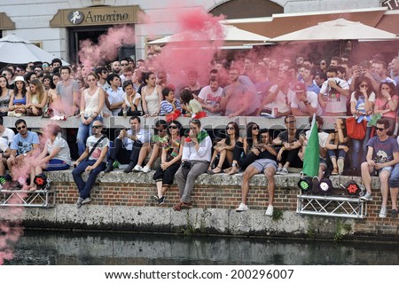 MILAN, ITALY-JUNE 20, 2014: italian soccer fans on the Naviglio Grande canal, watching the Brazil 2014 World Cup football match Italy vs Costa Rica, in Milan.