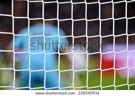 MILAN, ITALY-NOVEMBER 02, 2014: soccer goal net with blurry goalkeeper during the italian serie A soccer match AC Milan vs Palermo, at the san siro stadium, in Milan.