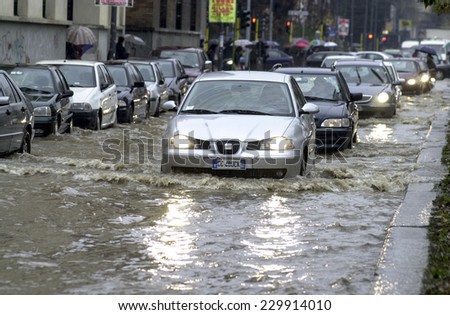 MILAN, ITALY-NOVEMBER 26, 2002: cars driving on a flooded road during a flood caused by heavy rain, in Milan.