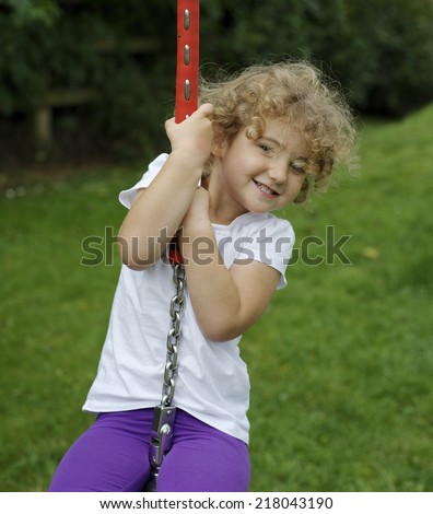 Young child playing on a rope swing.