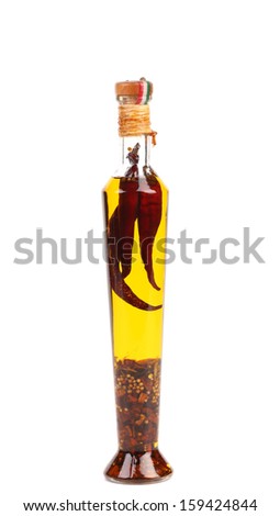 Red chillies preserved in bottle of olive oil. Isolated on a white backgropund.