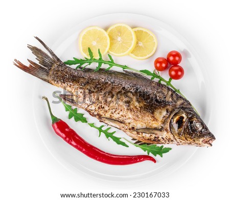 Grilled seabass with vegetables on plate. Isolated on a white background.