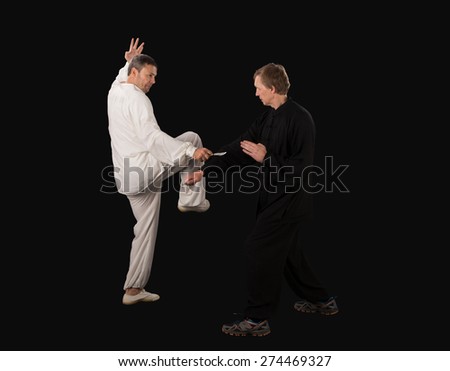 Karate fighters. Training fight. Located on the black background.