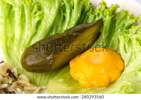 Pickled squash and cucumber vegetables on fresh lettuce leaf. Macro. Photo can be used as a whole background.