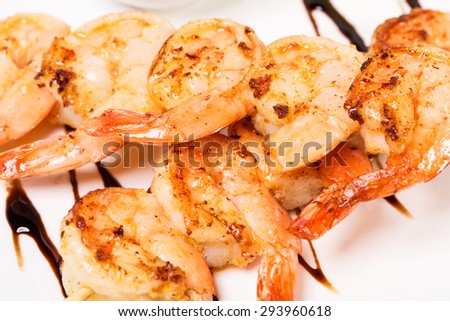 Delicious grilled shrimps on skewers covered with dark soya sauce. Macro. Photo can be used as a whole background.