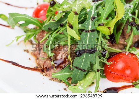 Warm beef shish kebab with fresh arugula and grated parmesan cheese covered with balsamic vinegar. Macro. Photo can be used as a whole background.