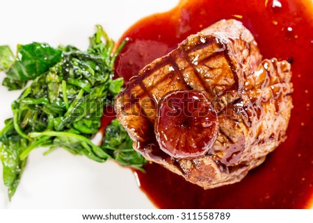 Delicious grilled fillet mignon steak with chard covered with red wine sauce. Macro. Selective focus. Photo can be used as a whole background.
