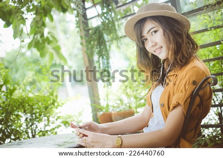 Woman listening to music with earphones in the park, Color effect