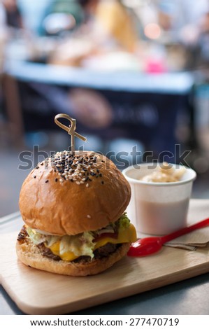 Beef burger on wooden plate in restaurant