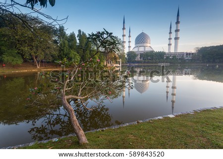 a beautiful view of Sultan Salahuddin Abd Aziz Mosque or Masjid Negeri Shah Alam (in Malay) with reflection from the lake, sunrise moment