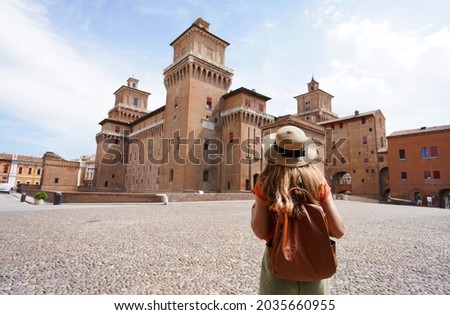 Travel in Italy. Rear view of traveler girl walking towards Este Castle (Castello Estense) of Ferrara, Italy. Foto d'archivio © 