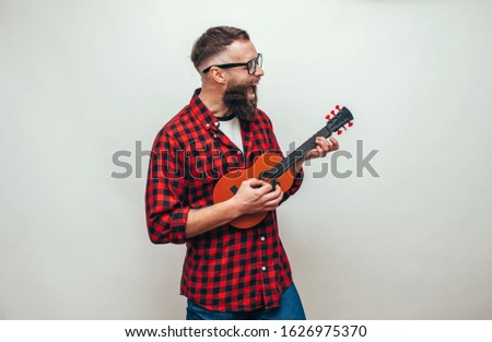 Similar – Image, Stock Photo Cheerful man playing ukulele guitar