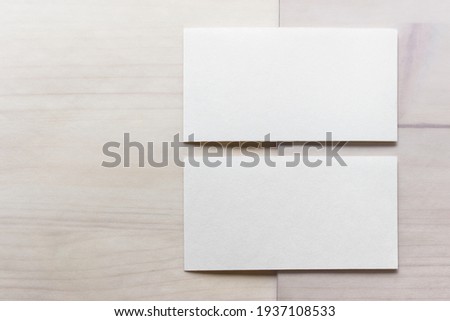 Mockup template with two blank business cards on wooden background.