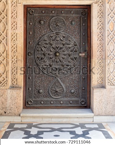 Closed wooden aged door with ornate bronzed floral patterns at the mosque of The Manial Palace of Prince Mohammed Ali Tewfik, Cairo, Egypt
