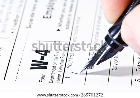 The process of filling out the W-4 form, shallow depth of field
