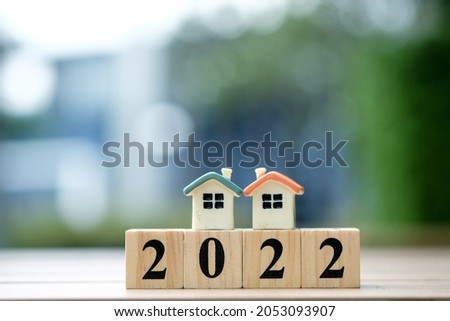 Two house model on 2022 wooden blocks number. New year property investment concept.