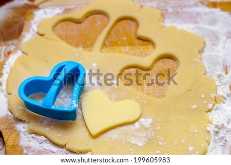 Hearts shaped cookie cutter on raw cookie dough