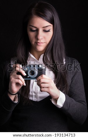 Young beautiful brunette woman photographer holding vintage film camera