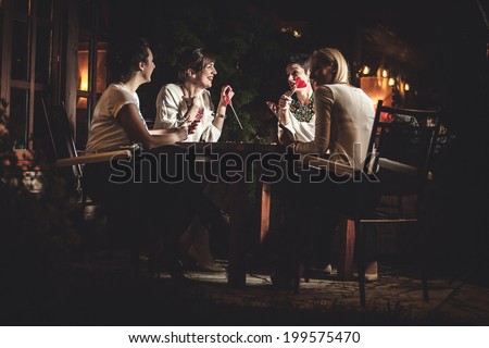 Four attractive women night out having dinner in a restaurant