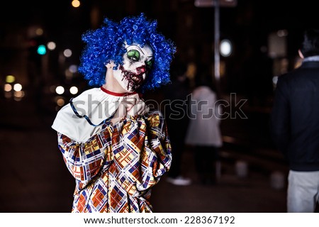 Crazy ugly grunge evil clown in town on Halloween making people shock and scared