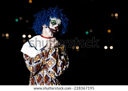 Crazy ugly grunge evil clown in town on Halloween making people shock and scared