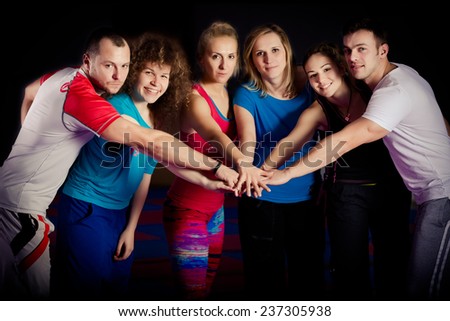 Fitness workout team motivation.Group of athletic healthy adults in gym giving group high five.United hands. Conceptual photo of teamwork